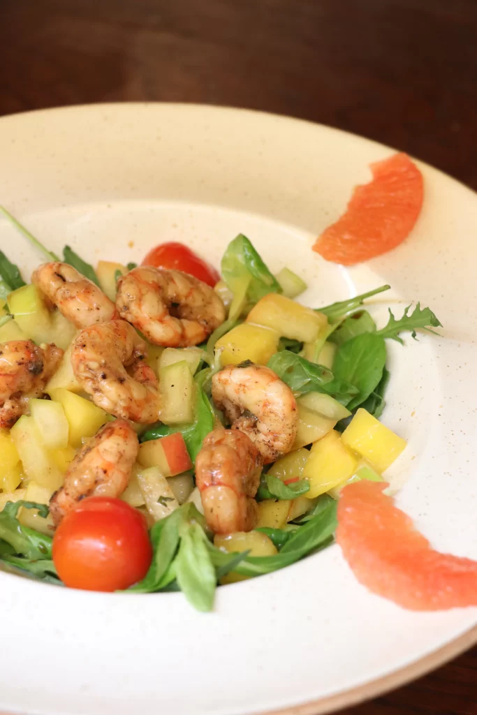 Colorful shrimp and fruit salad with arugula, cherry tomatoes, and citrus wedges served at Konoba Malo Misto in Zadar
