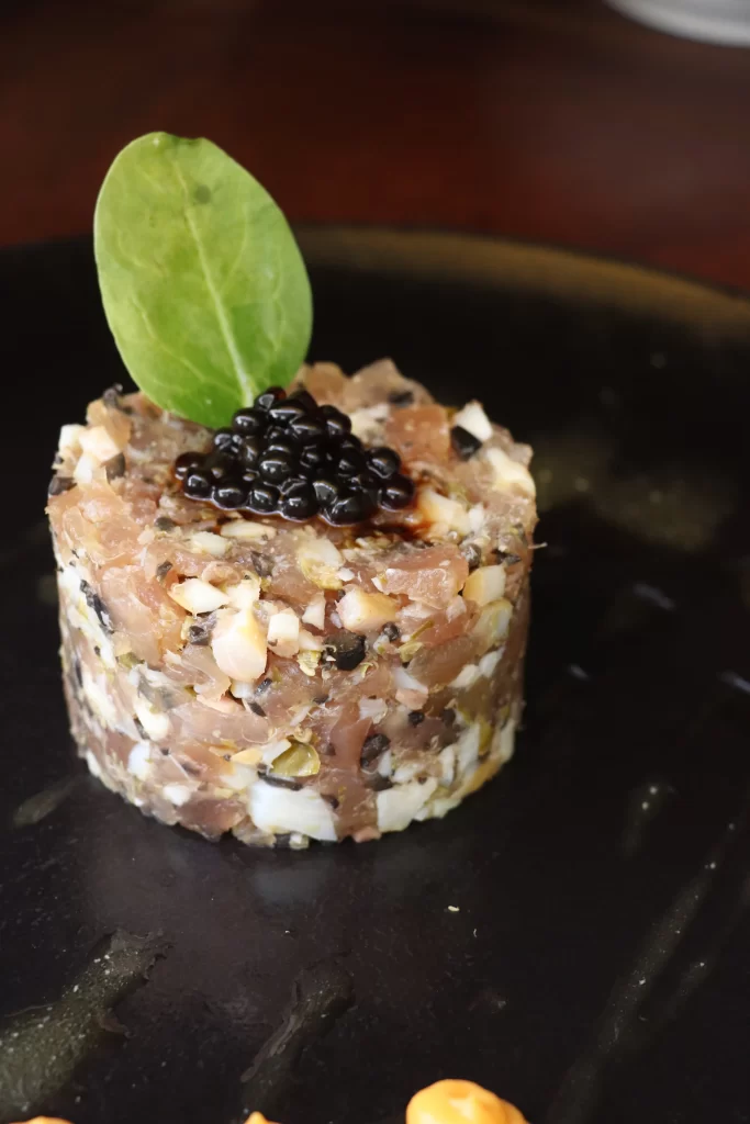 Tuna tartare with olives and capers, topped with balsamic pearls and a fresh basil leaf at Konoba Malo Misto restaurant in Zadar