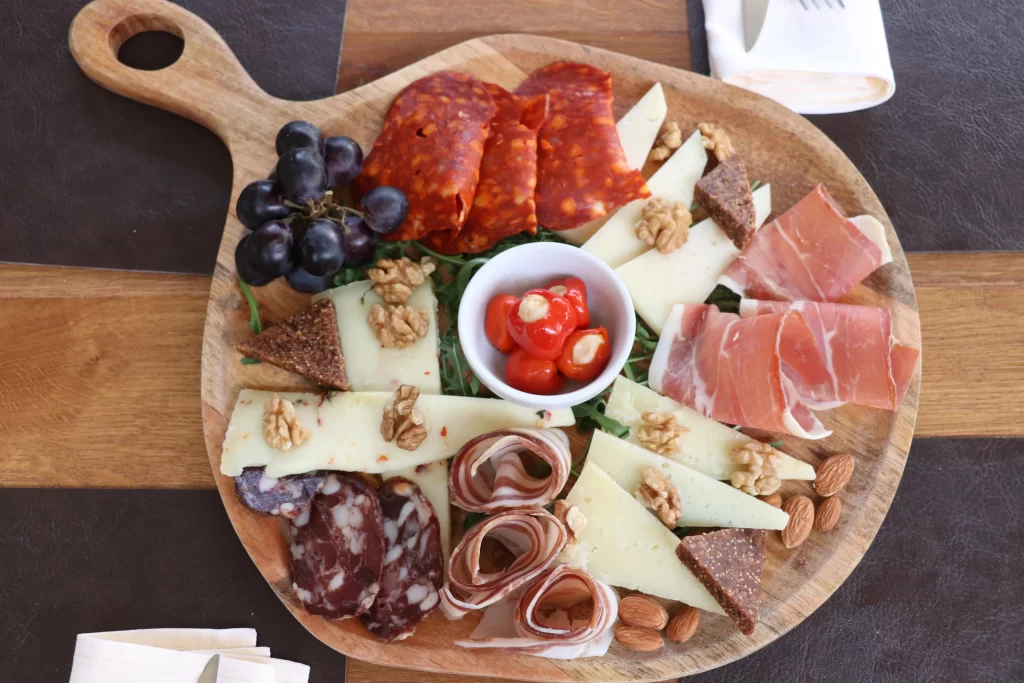 Dalmatian charcuterie board with prosciutto, cured meats, cheeses, nuts, grapes, and cherry tomatoes served at Konoba Malo Misto in Zadar