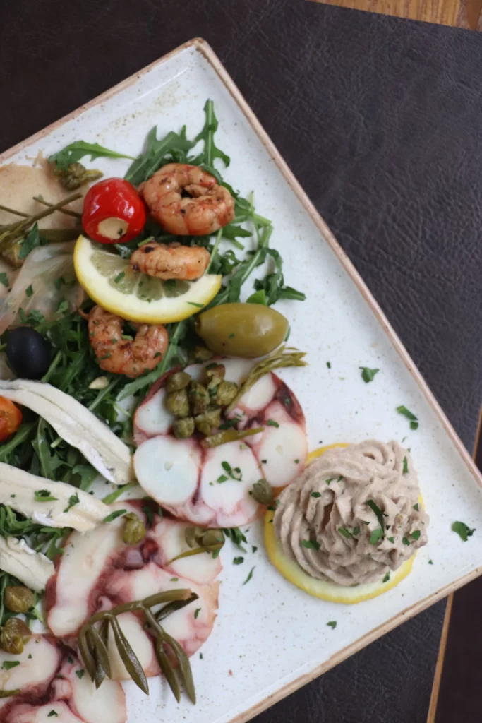 Seafood platter featuring octopus carpaccio, shrimp, mussels, anchovies, tuna pâté, and Mediterranean garnishes served at Konoba Malo Misto in Zadar
