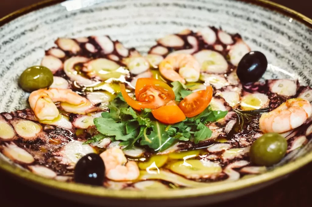 Octopus and shrimp carpaccio with olives and arugula at Konoba Malo Misto restaurant in Zadar